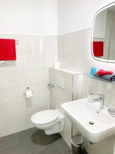 a white bathroom with a toilet and a sink at Hotel Post in Mühlacker