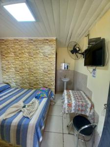 a bedroom with a bed and a table and a tv at Hotel em SBO - São Francisco in Santa Bárbara dʼOeste