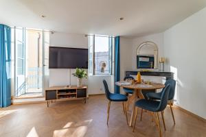 Una cocina y un comedor con mesa y sillas. en Le plus beau balcon des Arènes, en Nimes