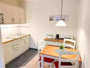a kitchen with a wooden table and white cabinets at Waldoase I inkl Sauna-und Schwimmbadnutzung in Bad Harzburg