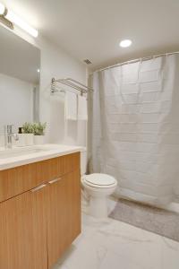 uma casa de banho com um WC, um lavatório e um chuveiro em Condo Steps Away From Crystal City Metro Station em Arlington