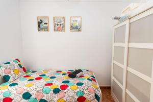 ein Schlafzimmer mit einem Bett mit einer bunten Bettdecke in der Unterkunft Happy Waves Home in Las Palmas de Gran Canaria