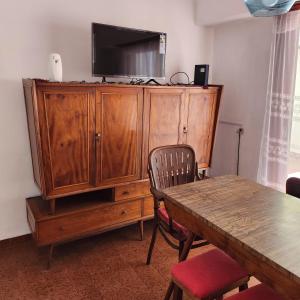 a large wooden cabinet with a television on top of it at Departamento Lo de Martha in Mar del Plata