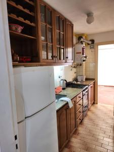 a kitchen with a white refrigerator and wooden cabinets at Departamento Lo de Martha in Mar del Plata
