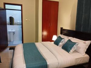 a bedroom with a large bed and a bathroom at Bwiranda Hotel in Kasese