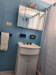 a bathroom with a sink and a mirror and a shower at Departamento Lo de Martha in Mar del Plata