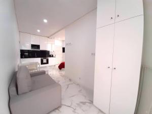 een witte woonkamer met een bank en een keuken bij VB Porto City Studio, by Flat in Porto in Porto
