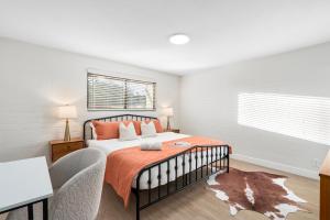 a bedroom with a bed with a orange blanket at Midtown Bliss with Pool & Sports Use & Laundry & Parking in Phoenix