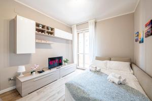 - une petite chambre avec un lit et une télévision dans l'établissement Homiday- Free Parking - Design Flat - Ospedale Cisanello, à Pise