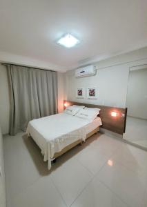 a bedroom with a white bed and a window at Apartamento Summer Beach Bombas in Bombas +18 photos