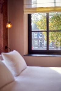 um quarto com uma cama e uma janela em The Yard hotel Noordkade em Veghel