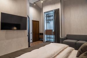 een slaapkamer met een bed, een bank en een flatscreen-tv bij Sherwood Chalet in Boekovel