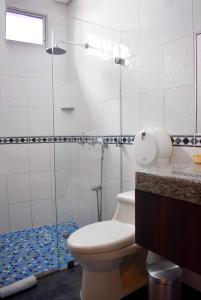 a bathroom with a toilet and a glass shower at Hotel Del Centro in Guayaquil