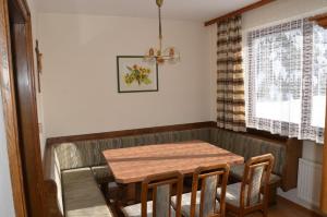 comedor con mesa de madera y sillas en Haus Grader en Kleinarl