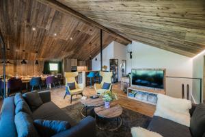 ein Wohnzimmer mit einem Sofa, einem TV und einem Tisch in der Unterkunft Chalet Ortles M in Sankt Valentin auf der Haide