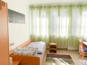 a bedroom with a bed and a window with green curtains at Hotel Post in Mühlacker