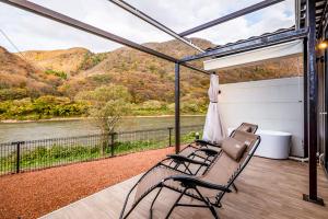 a screened porch with a view of a river and mountains at R;MOGAMI 