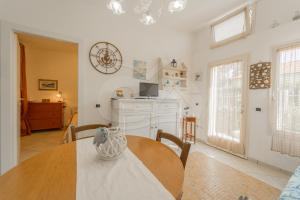 a dining room with a table and a kitchen at Villino Aloe - Goelba in Marina di Campo