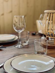 - une table en bois avec des assiettes et des verres à vin dans l'établissement Le Chalet de la Plage, à Sévrier