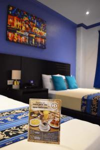 a hotel room with two beds and a sign on the bed at Hotel Del Centro in Guayaquil