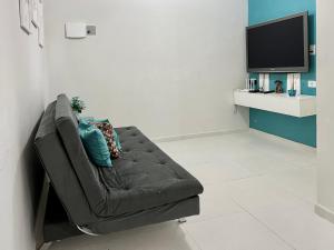 sala de estar con sofá y TV en Bella Peroba Flats #4 Tiffany - Maragogi - AL ' Acessibilidade Kids en Maragogi