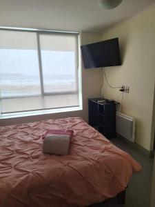 a bedroom with a bed and a large window at Alojamiento en la Serena - Chile in La Serena