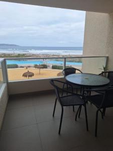 a balcony with a table and chairs and a view of the beach at Alojamiento en la Serena - Chile in La Serena
