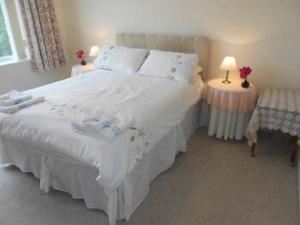 1 dormitorio con 1 cama blanca grande y 2 mesas en BOURNECOAST: LOVELY BUNGALOW NEAR THE SEA - HB2087, en Bournemouth