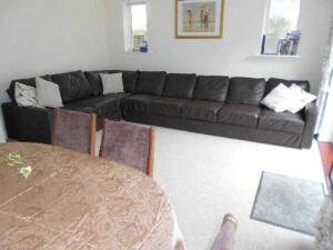 sala de estar con sofá negro y mesa en BOURNECOAST: LOVELY BUNGALOW NEAR THE SEA - HB2087, en Bournemouth