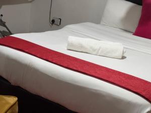 - un lit blanc avec une couverture rouge dans l'établissement Classic all ensuit 3 bedroom in kisumu town, à Kisumu