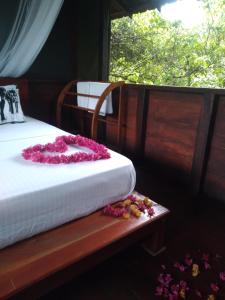 een slaapkamer met een bed met roze bloemen erop bij Dambulla Tree House in Dambulla