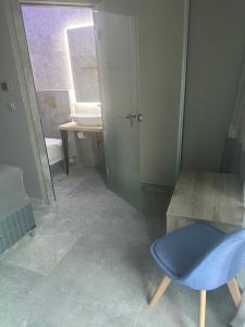 a bathroom with a blue chair and a sink at Barocco Park in Skala Potamias