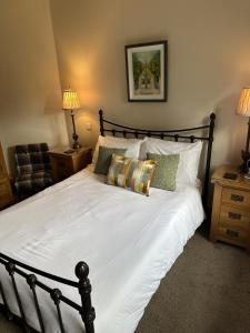 a bedroom with a large bed with white sheets and pillows at Dunhill Cottage B&B in Hillsborough