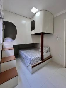 um quarto com uma cama e um candeeiro em Bella Peroba Flats #4 Tiffany - Maragogi - AL ' Acessibilidade Kids em Maragogi