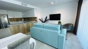 Il comprend un salon avec un canapé bleu et une cuisine. dans l'établissement Estepona South bay, à Estepona