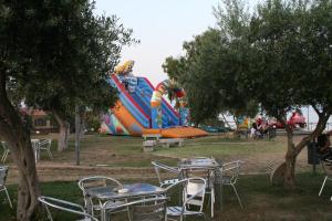 a group of tables and chairs in a park with an inflatable playground at Villa Rosanna in Capoterra
