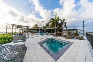 una piscina en un patio con sillas y árboles en Moderno, en Fort Lauderdale