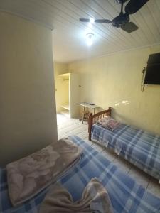een kamer met twee bedden en een tafel erin bij Hotel em SBO - Centro in Santa Bárbara dʼOeste