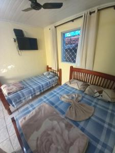 twee bedden in een kamer met een raam bij Hotel em SBO - Centro in Santa Bárbara dʼOeste