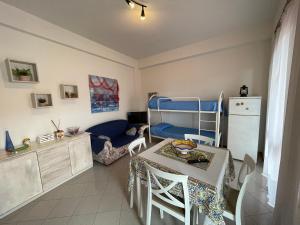 une petite chambre avec une table et un lit superposé bleu dans l'établissement PIETRA BIANCA, à Acireale 3 autres photos