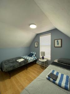 een slaapkamer op zolder met 2 bedden en een raam bij Private Room- Shediac Beach House in Shediac