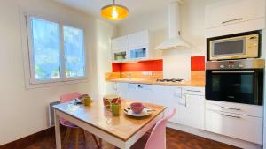 サント・マリー・ド・レにあるVilla à proximité de la plageのキッチン(テーブル、椅子、電子レンジ付)