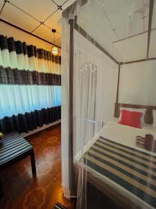 a bedroom with a bed and a window with curtains at Kawshan Home Stay in Hiriketiya