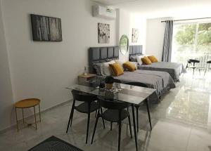 1 dormitorio con 1 cama, mesa y sillas en Horizonte Verde y Tranquilo, Respiro Verde en Santa Cruz de la Sierra