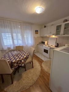 eine Küche mit einem Tisch und Stühlen im Zimmer in der Unterkunft Apartment Gataric Banja Luka in Banja Luka