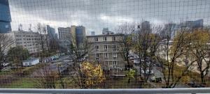 a view of a city from a wire fence at Apartament Koszutka - 100m od Spodka in Katowice