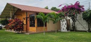 een klein huis met een palmboom in een tuin bij Hosteria SR in Pedernales