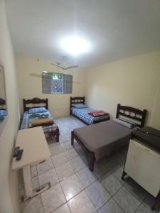 een kamer met 2 bedden en een tafel bij Hotel em SBO - Centro in Santa Bárbara dʼOeste