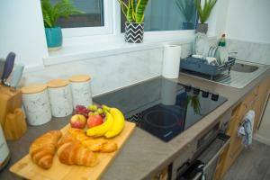 a cutting board with bananas and fruit on a kitchen counter at Bentley Bridge Wolverhampton 3 Bedrooms Entire House - Perfect for short or Long stay in Wednesfield