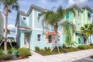 une maison bleue avec des palmiers devant elle dans l'établissement Margaritaville Cottages Orlando by Rentyl, à Orlando